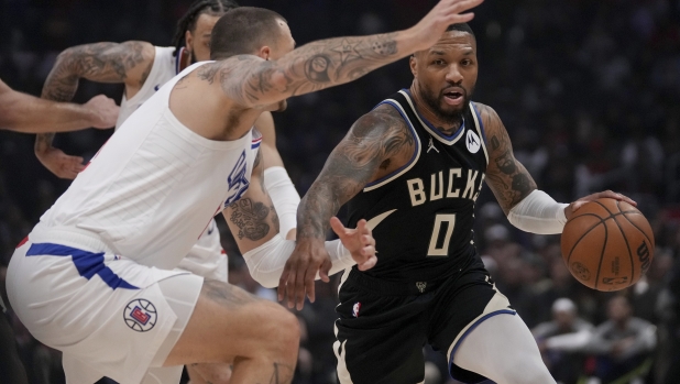 Milwaukee Bucks guard Damian Lillard (0) drives against Los Angeles Clippers center Daniel Theis during the first half of an NBA basketball game in Los Angeles, Sunday, March 10, 2024. (AP Photo/Eric Thayer)