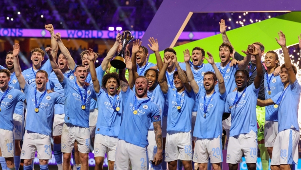Manchester City players celebrate with their winning trophy at the end of the FIFA Club World Cup 2023 football final match against Brazil's Fluminense at King Abdullah Sports City Stadium in Jeddah on December 22, 2023. (Photo by Giuseppe CACACE / AFP)