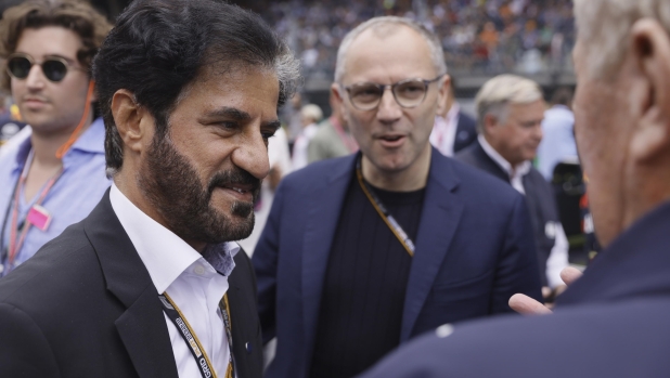 epa10063606 FIA President Mohammed Ben Sulayem (L) and Stefano Domenicali (C R), CEO of the Formula One Group walk at the starting grid ahead of the Formula One Grand Prix of Austria at the Red Bull Ring in Spielberg, Austria, 10 July 2022.  EPA/RONALD WITTEK