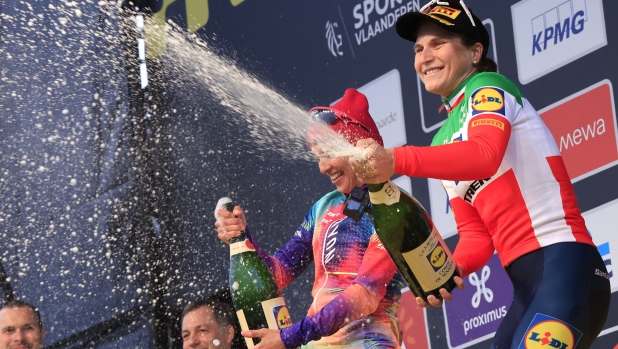 First place, Elisa Longo-Borghini of the Lidl-Trek team, right, celebrates on the podium with second place, Kasia Niewiadoma of the Canyon-SRAM team, left, during the Tour of Flanders in Oudenaarde, Belgium on Sunday, March 31, 2024. (AP Photo/Geert Vanden Wijngaert)