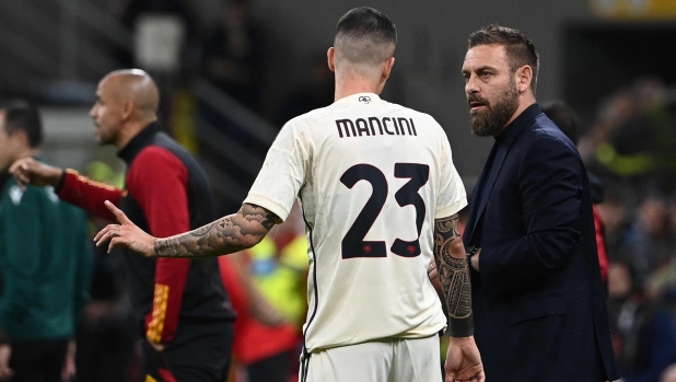 Roma's Italian defender #23 Gianluca Mancini speaks to Roma's Italian coach Daniele De Rossi during the UEFA Europa League football match between AC Milan and AS Roma at San Siro Stadium, in Milan on October 22, 2023. (Photo by Isabella BONOTTO / AFP)