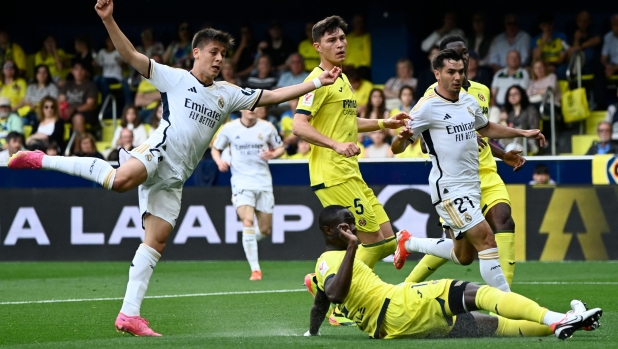 Real Madrid's Turkish midfielder #24 Arda Guler (L) reacts to scoring the opening goal during the Spanish League football match between Villarreal CF and Real Madrid CF at La Ceramica stadium in Vila-real on May 19, 2024. (Photo by JOSE JORDAN / AFP)