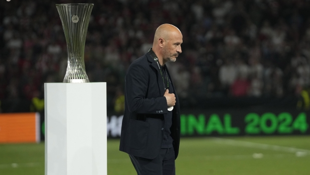 Fiorentina's head coach Vincenzo Italiano walks disappointed next to the Conference League trophy at the end of the Conference League final soccer match between Olympiacos FC and ACF Fiorentina at OPAP Arena in Athens, Greece, Thursday, May 30, 2024. Olympiacos won 1-0. (AP Photo/Thanassis Stavrakis)