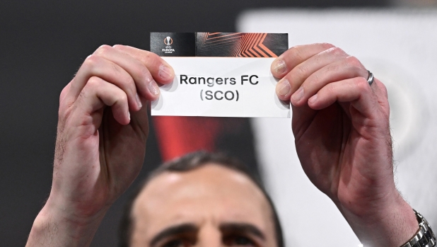 Irish former football international John O'Shea holds up the paper slip of Glasgow Rangers during the draw for the round of 16 of the 2023-2024 UEFA Europa League football tournament at the House of European Football in Nyon, on February 23, 2024. (Photo by Fabrice COFFRINI / AFP)