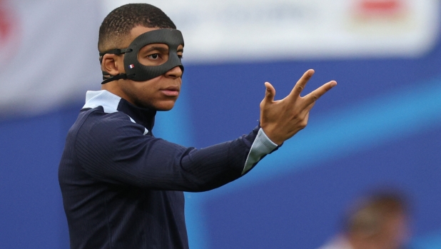 France's forward #10 Kylian Mbappe walks on the pitch wearing a protective during warm up prior to the  UEFA Euro 2024 Group D football match between the Netherlands and France at the Leipzig Stadium in Leipzig on June 21, 2024. (Photo by Adrian DENNIS / AFP)