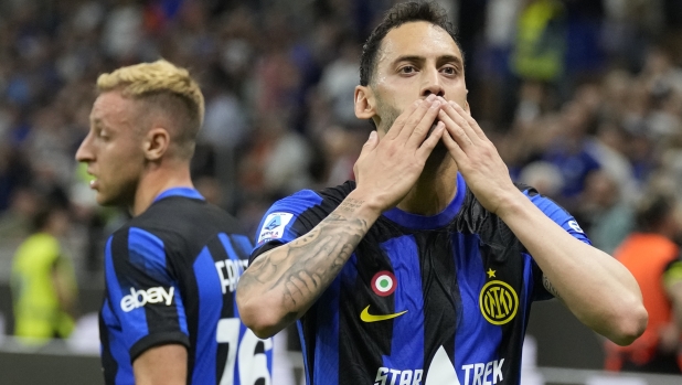 Inter Milan's Hakan Calhanoglu, right, celebrates after scoring his side's second goal during the Italian Serie A soccer match between Inter Milan and Cagliari at the San Siro stadium in Milan, Italy, Sunday, April 14, 2024. (AP Photo/Antonio Calanni)