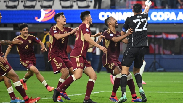 Venezuela's goalkeeper #22 Rafael Romo celebrates with teammates after blocking a penalty kick during the Conmebol 2024 Copa America tournament group B football match between Venezuela and Mexico at SoFi Stadium in Inglewood, California on June 26, 2024. (Photo by Patrick T. Fallon / AFP)