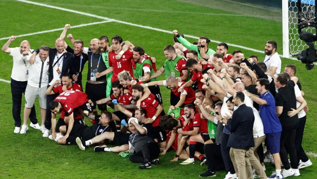 TOPSHOT - Georgia's players gather and celebrate after winning the UEFA Euro 2024 Group F football match between Georgia and Portugal at the Arena AufSchalke in Gelsenkirchen on June 26, 2024. (Photo by KENZO TRIBOUILLARD / AFP)