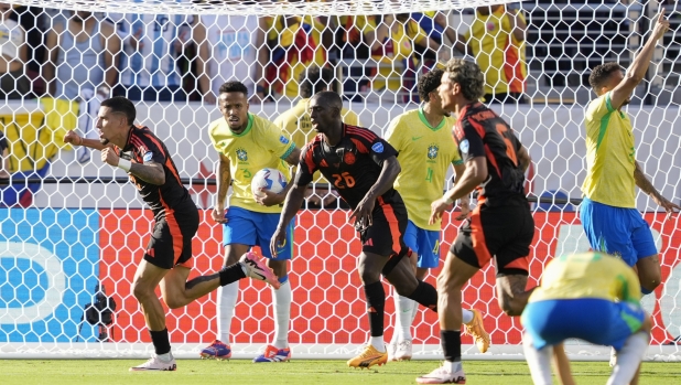 Colombia's Daniel Munoz, left, celebrates after scoring his side's first goal against Brazil during a Copa America Group D soccer match in Santa Clara, Calif., Tuesday, July 2, 2024. (AP Photo/Tony Avelar)