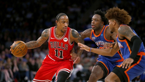 Chicago Bulls guard DeMar DeRozan, left, is defended by New York Knicks forward OG Anunoby, center, and guard Miles McBride, right, during the second half of an NBA basketball game Sunday, April 14, 2024, in New York. (AP Photo/John Munson)