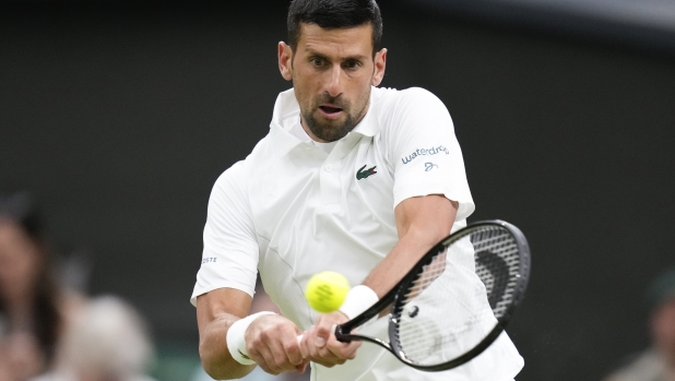 Novak Djokovic of Serbia plays a backhand return to Hulger Rune of Denmark during their fourth round match at the Wimbledon tennis championships in London, Monday, July 8, 2024. (AP Photo/Kirsty Wigglesworth)