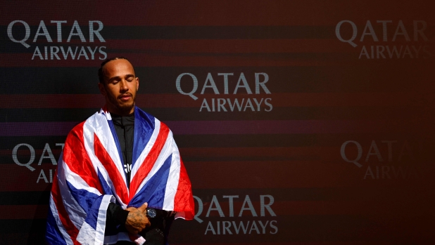 TOPSHOT - Mercedes' British driver Lewis Hamilton listens to the national anthem on the podium after winning the Formula One British Grand Prix at the Silverstone motor racing circuit in Silverstone, central England, on July 7, 2024. (Photo by BENJAMIN CREMEL / AFP)