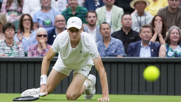 Jannik Sinner of Italy falls during his quarterfinal match against Daniil Medvedev of Russia at the Wimbledon tennis championships in London, Tuesday, July 9, 2024. (AP Photo/Alberto Pezzali)