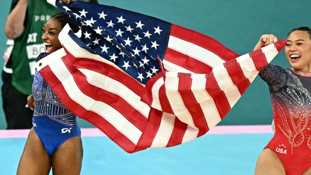 US' Simone Biles (L) and US' Sunisa Lee celebrates after winning respectively the gold and bronze medal at the end of the artistic gymnastics women's all around final of the Paris 2024 Olympic Games at the Bercy Arena in Paris, on August 1, 2024. (Photo by Gabriel BOUYS / AFP)