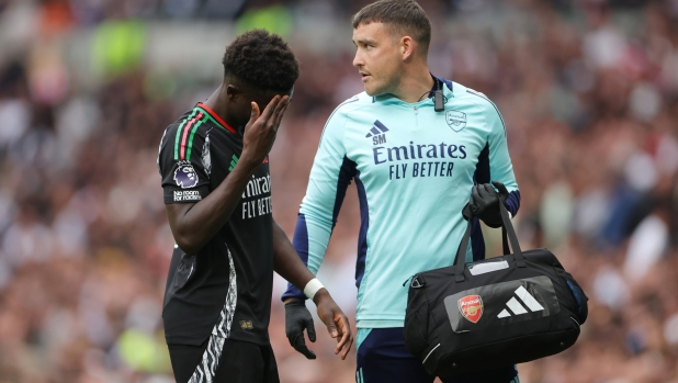 LONDON, ENGLAND - SEPTEMBER 15: Bukayo Saka of Arsenal receives medical treatment during the Premier League match between Tottenham Hotspur FC and Arsenal FC at Tottenham Hotspur Stadium on September 15, 2024 in London, England. (Photo by Alex Pantling/Getty Images)