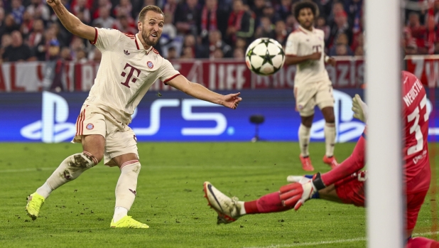 epa11610643 Harry Kane of Bayern (L) in action against goalkeeper Ivan Nevistic of Dinamo Zagreb (R) during the UEFA Champions League match between Bayern Munich and Dinamo Zagreb in Munich, Germany, 17 September 2024.  EPA/ANNA SZILAGYI