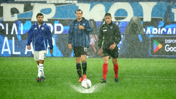 Referee Paride Tremolada checks the conditions of the field with capitains Atalanta's Marten De Roon and Comos Patrick Cutrone during the Italian Serie A soccer match Atalanta BC vs Como at Gewiss Stadium in Bergamo, Italy, 23 September 2024. ANSA/MICHELE MARAVIGLIA