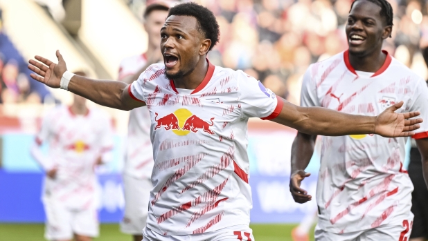 Leipzig's Lois Openda, front, celebrates after scoring the opening goal during the German Bundesliga soccer match between 1. FC Heidenheim and RB Leipzig in Heidenheim, Germany, Sunday, Oct. 6, 2024. (Harry Langer/dpa via AP)