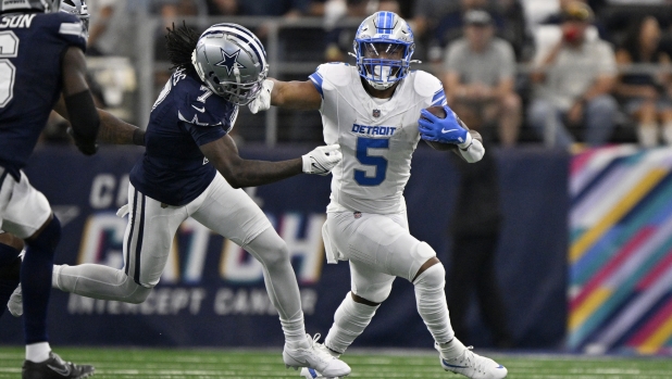 Detroit Lions running back David Montgomery (5) runs the ball as Dallas Cowboys cornerback Trevon Diggs (7) attempts to make the stop in the first half of an NFL football game in Arlington, Texas, Sunday, Oct. 13, 2024. (AP Photo/Jerome Miron)