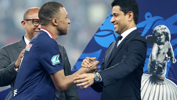 Paris Saint Germain's Qatari President Nasser Al-Khelaifi (R) shakes hands of Paris Saint-Germain's French forward #07 Kylian Mbappe (C) on the podium as he congratulates him on winning the French Cup Final football match between Olympique Lyonnais (OL) and Paris Saint-Germain (PSG) at the Stade Pierre-Mauroy, in Villeneuve-d'Ascq, northern France on May 25, 2024. (Photo by FRANCK FIFE / AFP)