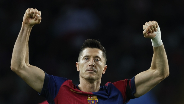 Barcelona's Robert Lewandowski celebrates after scoring the opening goal from the penalty spot during a Spanish La Liga soccer match between Barcelona and Sevilla at the Olimpic Lluis Companys stadium in Barcelona, Spain, Sunday, Oct. 20, 2024. (AP Photo/Joan Monfort)