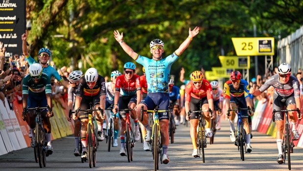 TOPSHOT - Britain's Mark Cavendish (C) celebrates as he crosses the finish line during the third Tour de France Singapore Criterium race in Singapore on November 10, 2024. 39-year-old Cavendish, the record stage winner on the Tour with 35, competes in the final race of his storied career in Singapore. (Photo by Roslan RAHMAN / AFP)