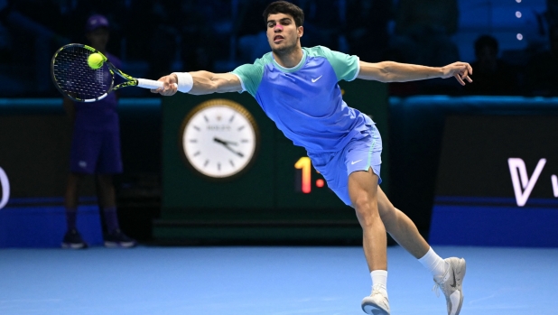 Spain's Carlos Alcaraz hits a return to Russia's Andrey Rublev during their match at the ATP Finals tennis tournament in Turin on November 13, 2024. (Photo by Marco BERTORELLO / AFP)