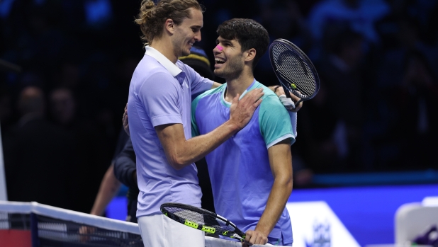 TURIN, ITALY - NOVEMBER 15: A victorious Alexander Zverev of Germany (L) embraces Carlos Alcaraz of Spain at the net at the end of their men's singles match on day six of the Nitto ATP finals 2024 at Inalpi Arena on November 15, 2024 in Turin, Italy.  (Photo by Clive Brunskill/Getty Images)