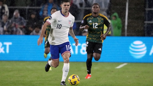 United States' Christian Pulisic (10) brings the ball down the pitch as Jamaica's Tayvon Gray (12) gives chase during the second half in a CONCACAF Nations League quarterfinal second leg soccer match Monday, Nov. 18, 2024, in St. Louis. (AP Photo/Jeff Roberson)