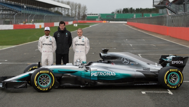 Mercedes AMG Petronas Formula One drivers Britain's Lewis Hamilton (L) and Finland's Valtteri Bottas (R) pose with Mercedes head Austria's Toto Wolff by the new 2017 season Mercedes W08 EQ Power+ Formula One car at its launch event at Silverstone motor racing circuit near Towcester, central England on February 23, 2017. (Photo by OLI SCARFF / AFP)