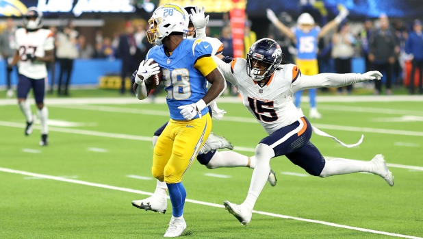 INGLEWOOD, CALIFORNIA - DECEMBER 19: Hassan Haskins #28 of the Los Angeles Chargers runs the ball to score a 34 yard touchdown against Nik Bonitto #15 of the Denver Broncos during the fourth quarter in the game at SoFi Stadium on December 19, 2024 in Inglewood, California.   Sean M. Haffey/Getty Images/AFP (Photo by Sean M. Haffey / GETTY IMAGES NORTH AMERICA / Getty Images via AFP)