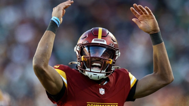 LANDOVER, MARYLAND - DECEMBER 22: Jayden Daniels #5 of the Washington Commanders celebrates his touchdown pass against the Philadelphia Eagles during the fourth quarter at Northwest Stadium on December 22, 2024 in Landover, Maryland.   Timothy Nwachukwu/Getty Images/AFP (Photo by Timothy Nwachukwu / GETTY IMAGES NORTH AMERICA / Getty Images via AFP)