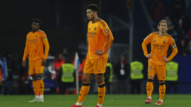 Real Madrid's Jude Bellingham, centre and Luka Modric, right, react after Espanyol's Carlos Romero scored the opening goal during a Spanish La Liga soccer match between Espanyol and Real Madrid at the Lluis Companys Olympic Stadium in Barcelona, Spain, Saturday Feb.1, 2025. (AP Photo/Joan Monfort)