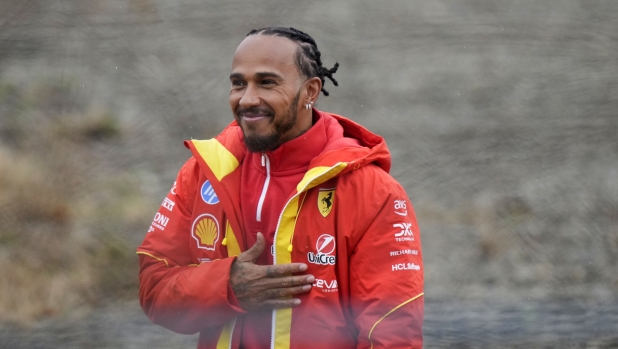 British driver Lewis Hamilton cheers Ferrari fans gathered outside the track, after testing a Ferrari Formula One SF-23, in Fiorano Modenese, Italy, Wednesday, Jan.22, 2025. (AP Photo/Luca Bruno)