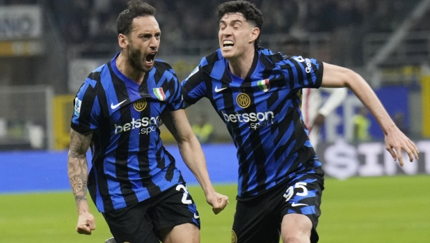 Inter Milan's Hakan Calhanoglu, left, celebrates with Alessandro Bastoni after scoring his side's second goal during the Serie A soccer match between Inter Milan and Monza at the San Siro stadium in Milan, Italy, Saturday, March 8, 2025. (AP Photo/Luca Bruno)