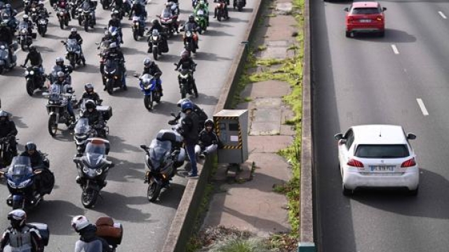 I motociclisti in strada davanti a una postazione autovelox fissa. Afp