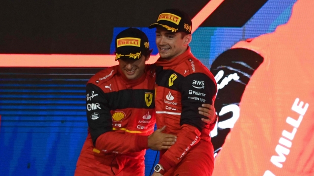 Ferrari's Spanish driver Carlos Sainz Jr (L) and Ferrari's Monegasque driver Charles Leclerc celebrate on the podium after the Bahrain Formula One Grand Prix at the Bahrain International Circuit in the city of Sakhir on March 20, 2022. (Photo by OZAN KOSE / AFP)