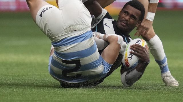 Fiji's Kaminieli Rasaku, front right, is tackled by Argentina's Santiago Vera Feld (2) and Marcos Moneta, back, during the HSBC Canada Sevens championship final rugby match, in Vancouver, British Columbia, Sunday, April 17, 2022. (Darryl Dyck/The Canadian Press via AP)