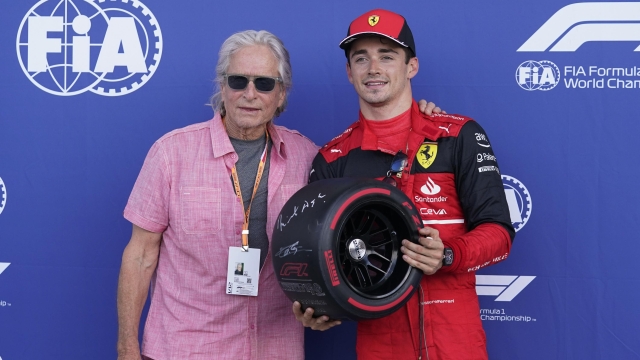 Ferrari driver Charles Leclerc of Monaco poses with actor Michael Douglas after winning pole position during qualifying for the Formula One Miami Grand Prix auto race at the Miami International Autodrome, Saturday, May 7, 2022, in Miami Gardens, Fla. (AP Photo/Darron Cummings)