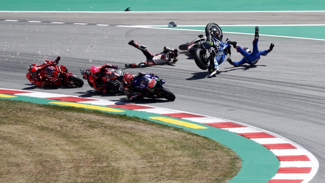 Spain's rider Alex Rins of the Team SUZUKI ECSTAR, top right, and Japan's rider Takaaki Nakagami of the LCR Honda IDEMITSU and Italian rider Francesco Bagnaia of the Ducati Lenovo Team, left, fall down during the MotoGP race of the Catalunya Motorcycle Grand Prix at the Catalunya racetrack in Montmelo, just outside of Barcelona, Spain, Sunday, June 5, 2022. (AP Photo/Joan Monfort)