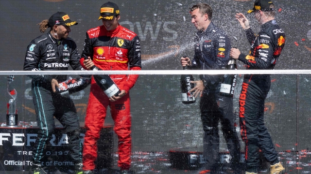 TOPSHOT - Red Bull Racing's Dutch driver Max Verstappen (L), Ferrari's Spanish driver Carlos Sainz Jr (2nd L) and Mercedes' British driver Lewis Hamilton (L) celebrate on the podium after the Canada Formula 1 Grand Prix on June 19, 2022, at Circuit Gilles-Villeneuve in Montreal. - Max Verstappen tightened his grip on a second successive world championship with an assured win in Sunday's Canadian Grand Prix. Ferrari's Carlos Sainz took second with Lewis Hamilton in third for Mercedes. (Photo by Jim WATSON / AFP)