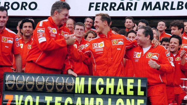 Michael Schumacher festeggia con il team Ferrari il secondo posto al gp del Belgio, 29 agosto 2004. ANSA / Oliver Weiken