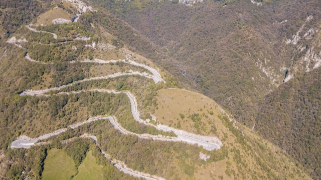 Drone aerial view of the mountain road in Italy that connects the village of Nebro to Selvino. Amazing aerial view of the mountain bends creating beautiful shapes