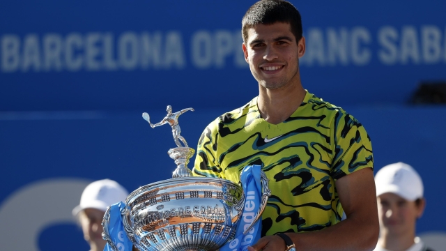 Carlos Alcaraz, of Spain, poses with the trophy after winning the final Godo tennis tournament against Stefanos Tsitsipas, of Greece, in Barcelona, Spain, Sunday, April 23, 2023. (AP Photo/Joan Monfort)