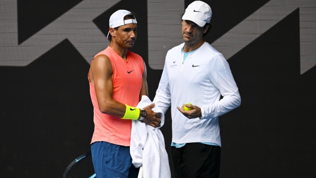 epa10406153 Rafael Nadal (L) of Spain speaks to coach Carlos Moya (R) of Spain during a practice session ahead of the 2023 Australian Open tennis tournament at Melbourne Park in Melbourne, Australia, 15 January 2023.  EPA/LUKAS COCH AUSTRALIA AND NEW ZEALAND OUT