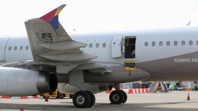 An opened door of an Asiana Airlines plane is seen at Daegu International Airport in Daegu on May 26, 2023, after it was manually opened by a passenger just 200 metres above the ground before landing causing some to have breathing difficulty but with no major injuries. (Photo by YONHAP / AFP) / - South Korea OUT / REPUBLIC OF KOREA OUT  NO ARCHIVES  RESTRICTED TO SUBSCRIPTION USE