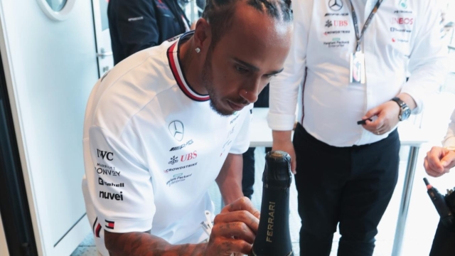 Lewis Hamilton firma la bottiglia all'asta