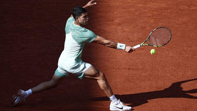 Spain's Carlos Alcaraz Garfia plays a backhand return to Italy's Flavio Cobolli during their men's singles match on day two of the Roland-Garros Open tennis tournament at the Court Suzanne-Lenglen in Paris on May 29, 2023. (Photo by Anne-Christine POUJOULAT / AFP)