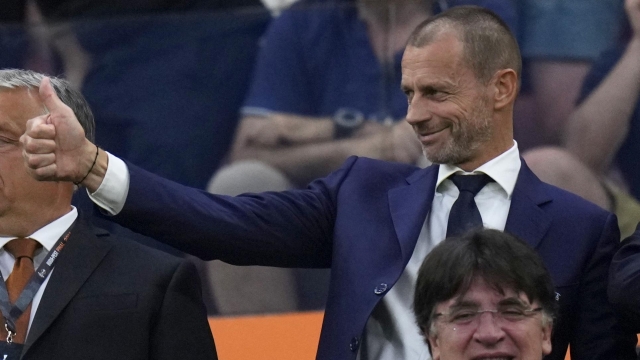 UEFA president Aleksander Ceferin, center, gestures next to Hungarian Prime Minster Viktor Orban, left, on the stands during the Europa League final soccer match between Sevilla and Roma, at the Puskas Arena in Budapest, Hungary, Wednesday, May 31, 2023. (AP Photo/Petr David Josek)