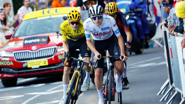 UAE Team Emirates' Slovenian rider Tadej Pogacar wearing the best young rider's white jersey (R) cycles ahead of Jumbo-Visma's Danish rider Jonas Vingegaard wearing the overall leader's yellow jersey in the final ascent of Saint-Gervais-les-Bains in the last kilometers of the 15th stage of the 110th edition of the Tour de France cycling race, 179 km between Les Gets Les Portes du Soleil and Saint-Gervais Mont-Blanc, in the French Alps, on July 16, 2023. (Photo by Etienne GARNIER / POOL / AFP)